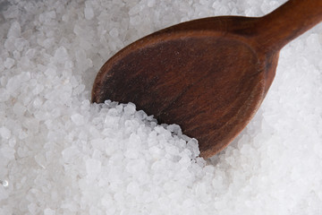Wooden spoon in sea salt. Sea salt close up
