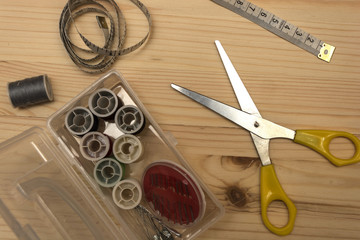 On wooden table are the tools for sewing