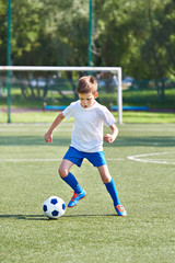 Boy soccer player running with ball