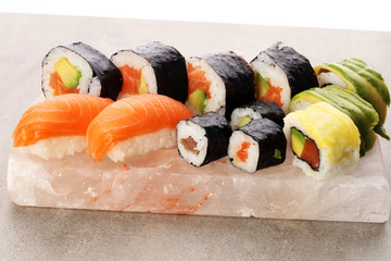 close up of sashimi sushi set with chopsticks and soy - sushi roll with salmon and sushi roll with...