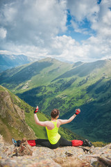 Fototapeta premium Woman doing exercise on the top of mountain