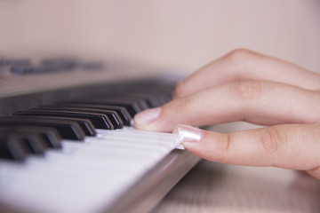 Fototapeta na wymiar Beautiful girls hand playing electronic piano keyboards.