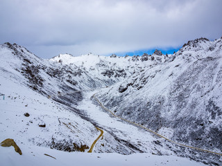 Aerial view of highway at the valley of snow mountain in Sichuan