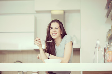 Beautiful young  woman breakfast cereals in the kitchen