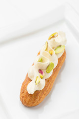 Eclair with vanilla cream and pistachio