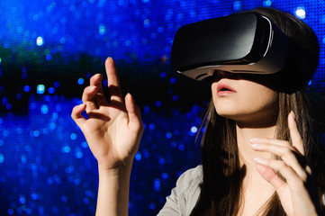 a beautiful girl wearing a virtual reality device, standing on the background of the sky