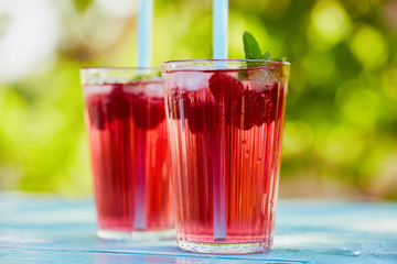 Close up of summer lemonade with raspberry and leaves mint