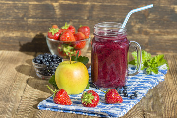 Health smoothie from strawberry, blueberry and banana in Mason jar mug