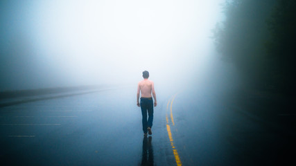 Homme torse nu qui marche sur une route brumeuse dans le Parc National Great Smoky Mountains dans le Tennessee aux Etats Unis