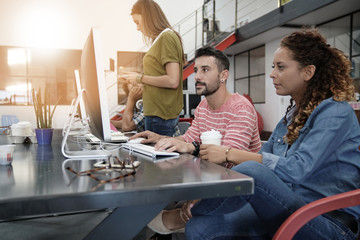 Start-up people working on desktop in co-working space