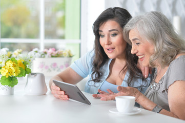 Two elderly girlfriends with a tablet 