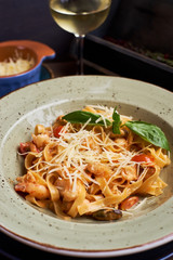 Pasta with seafood and cheese. Glass of white wine. Rustic style.