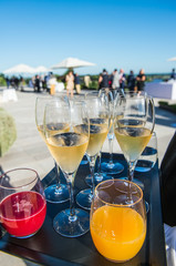 Waiter serving champagne and fruit juice on a tray