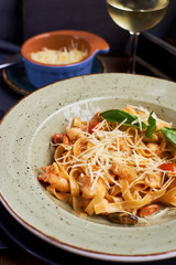Pasta with seafood and cheese. Glass of white wine. Rustic style.