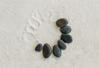 Fototapeta na wymiar black stones on white sand background