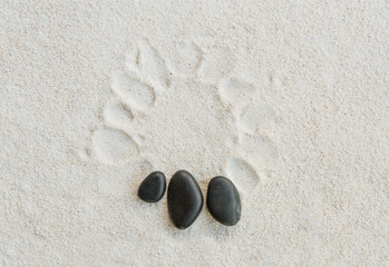 Fototapeta na wymiar black stones on white sand background