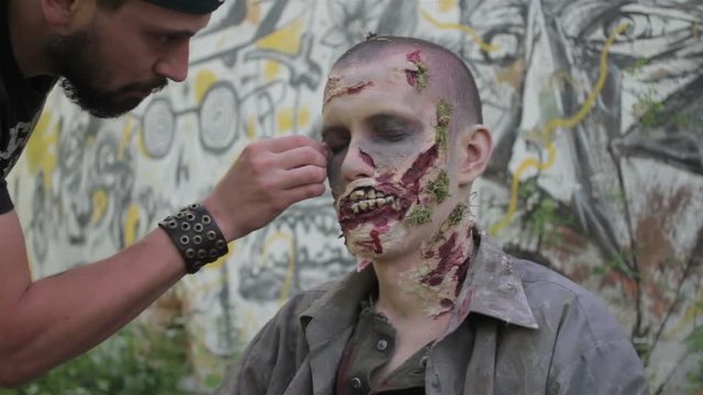 Makeup master creates zombie in the open air.