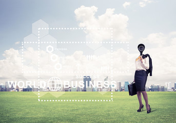 Camera headed woman standing on green grass against modern citys