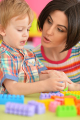 Fototapeta premium Young mother playing with son