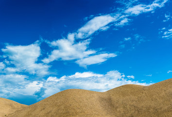 Fototapeta na wymiar Sand dunes on the background of beautiful cloudy sky.