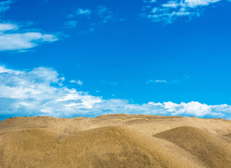 Sand dunes on the background of beautiful cloudy sky.