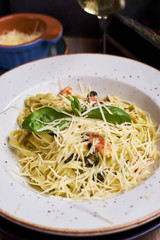 Closeup view of plate with traditional italian pasta with chiken and cheese. Glass of wine.