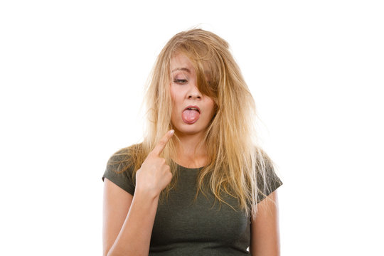 Sad blonde woman with messy hair pointing tongue