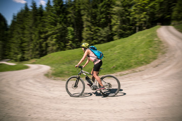 Frau  fährt auf eBike Berg hinab