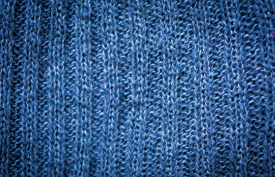 Texture of woolen material. Background with a blue knitted pattern.