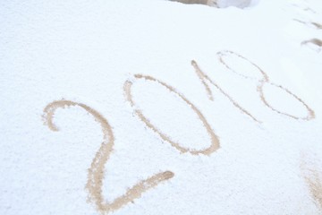 Happy New Year, 2018. New Year inscription on the snow. Winter day. Handwritten 