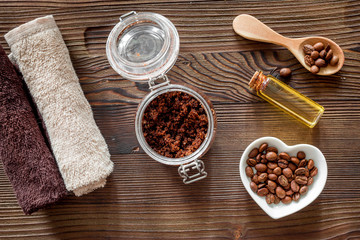Composition of spa treatment. Coffee scrub, coffee salt and oil on wooden table background top view