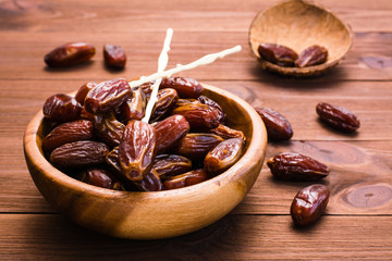 Sweet dried dates fruit in a wooden bowl on the table