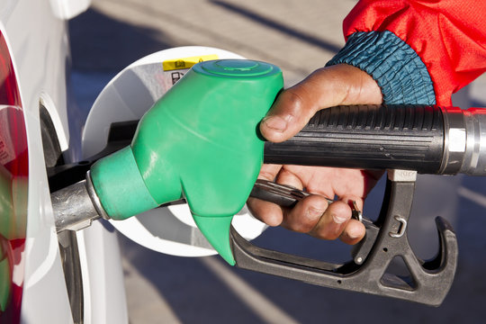 Male hand using a green petrol pump