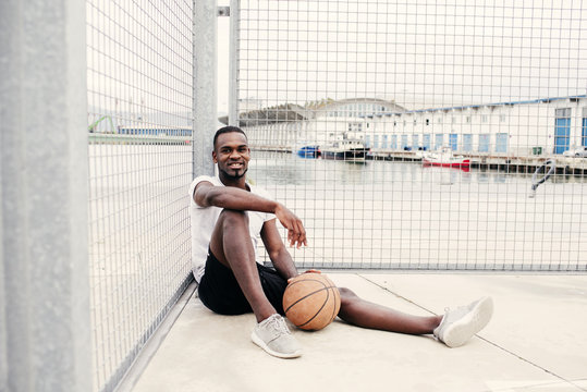 Confident man sitting with basketball