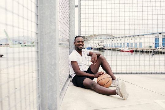 Confident man sitting with basketball