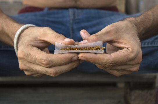 Hands of man rolling a joint