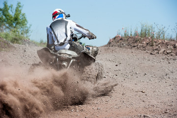 ATV rider creates a large cloud of dust and debris