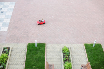 Obraz premium Top view of the toy red car for children in the yard