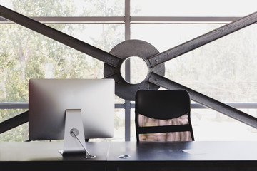 Computer, desk and armchair at the modern open space co-working