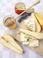 Cheeseboard. Cheese with blue mold, pears, apple and honey.