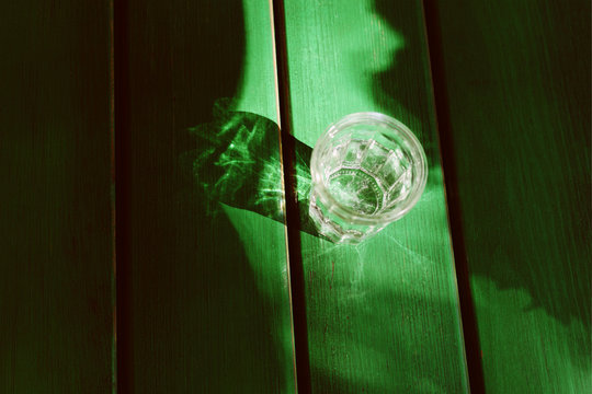 Glass of water on the green wooden table