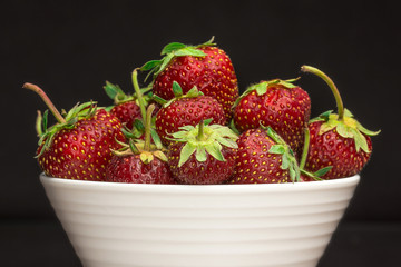 Bowl of strawberries on black 