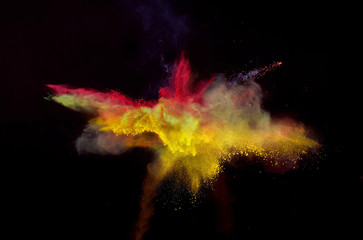 Bizarre color blasiing of powder paint and flour combined exploding in front of a black background...