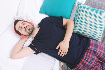 Man listening to music in bed. © Mego-studio