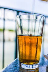 Macro closeup of melted iced tea and straw in glass