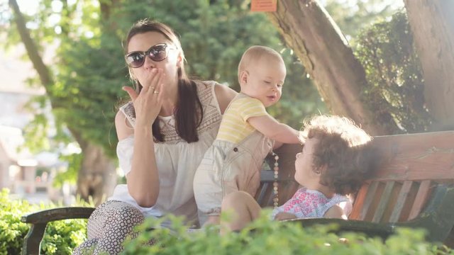 Young mom relaxing with her beloved little children