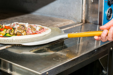 italian pizza coming ou of  out  burning pizza oven.