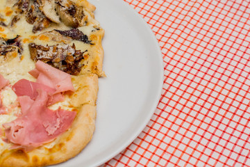 Fresh baked pizza with melted cheese, Bacon, meat  on a white plate on a red white background. Italian food, menu, restaurant concept, space for text