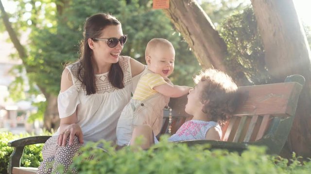 Young mom relaxing with her beloved little children