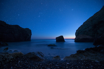 Scenic rocky seashore at sunset under the stars